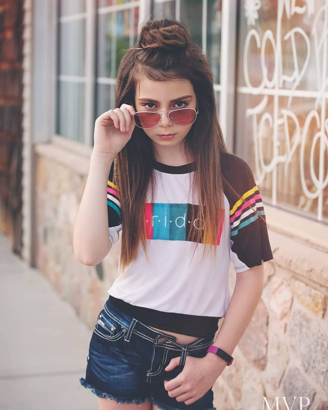 Sleek Braided Ponytail: Teen Hairstyles Summer 2026 A teen girl with sleek, high ponytail with braided details, perfect for cute teen hairstyles summer 2026. This dynamic, athletic-inspired look features a smooth crown leading to a textured braid wrapped around the base, ideal for staying cool.
