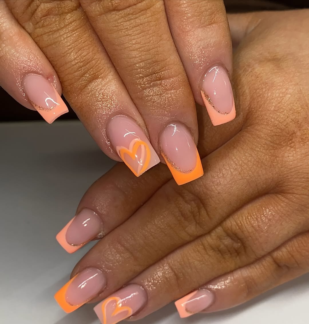 Vibrant Orange French Tips with Subtle Heart Art