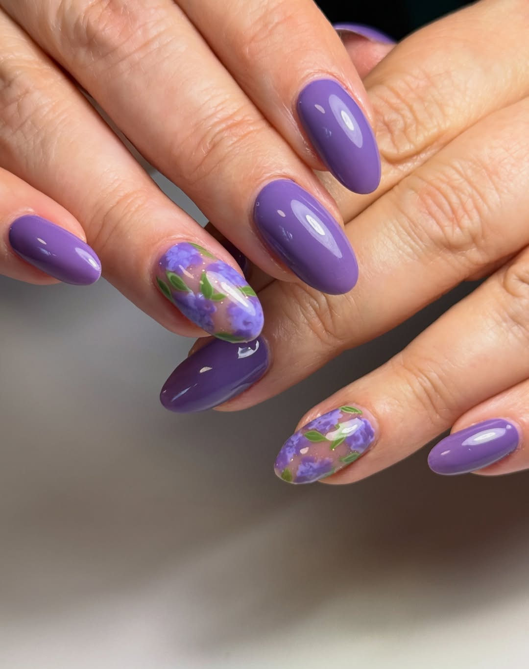 Vibrant Purple Oval Nails with Floral Art Accents