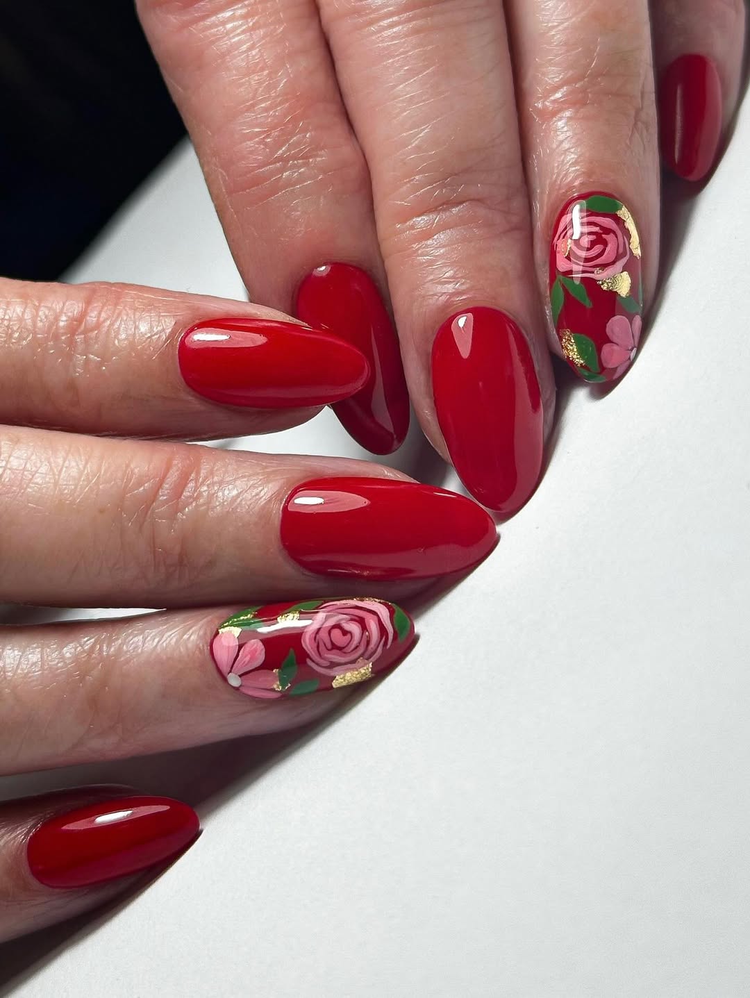 Vibrant Red Oval Nails with Floral Gold Leaf Accents