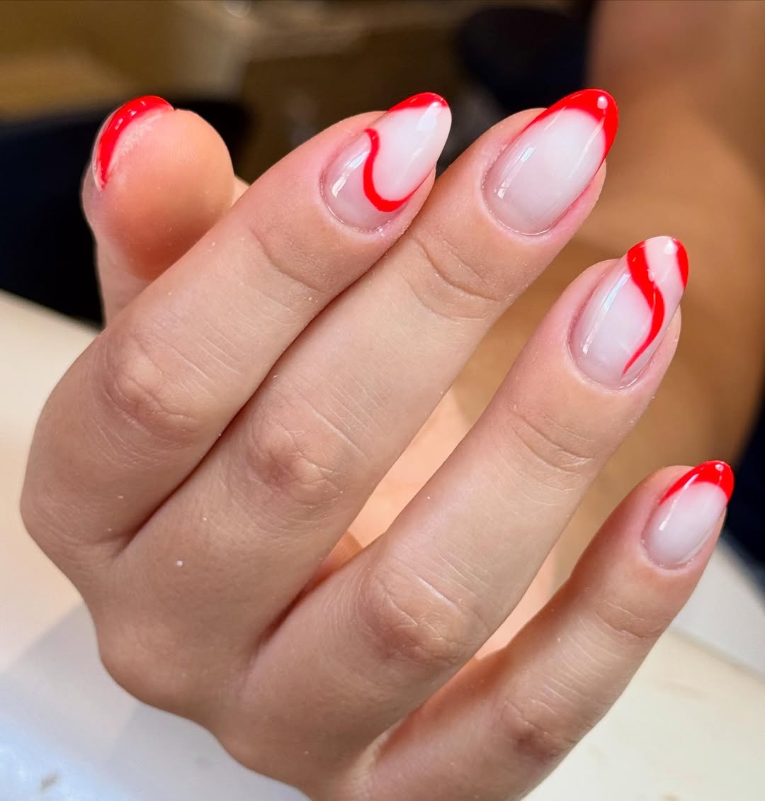 Vibrant Red Swirl French Tip Almond Nails