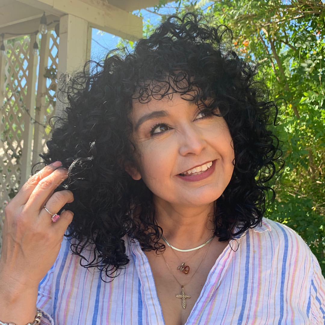25 Stunning Hairstyles for Older Women in 2026 17 Bouncy Shoulder-Length Black Curls With Wispy Bangs