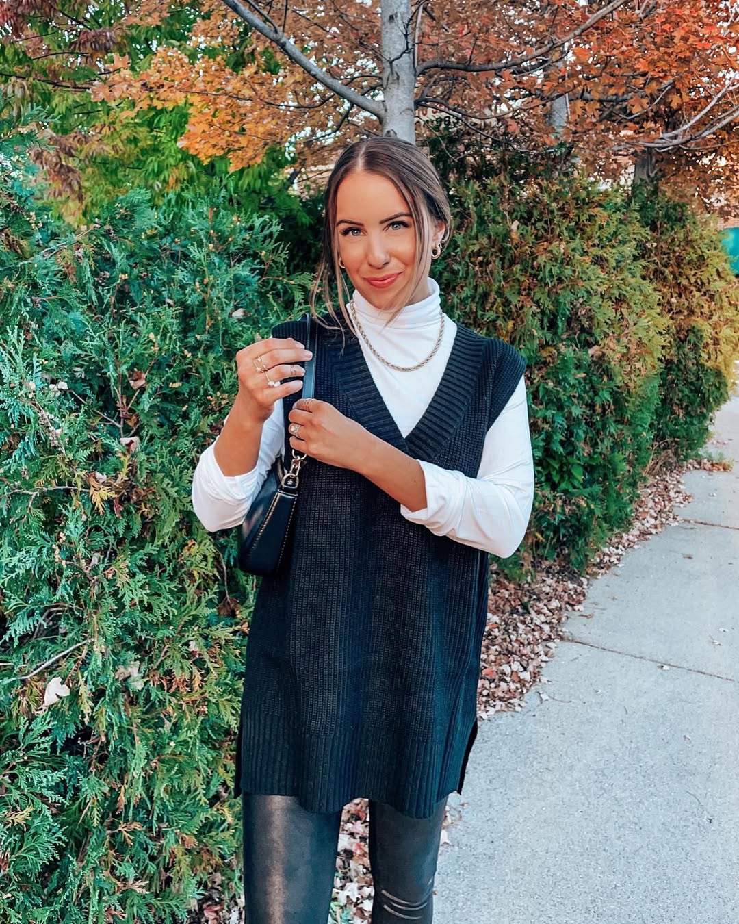 Chic Black Vest Over White Turtleneck With Faux Leather Pants