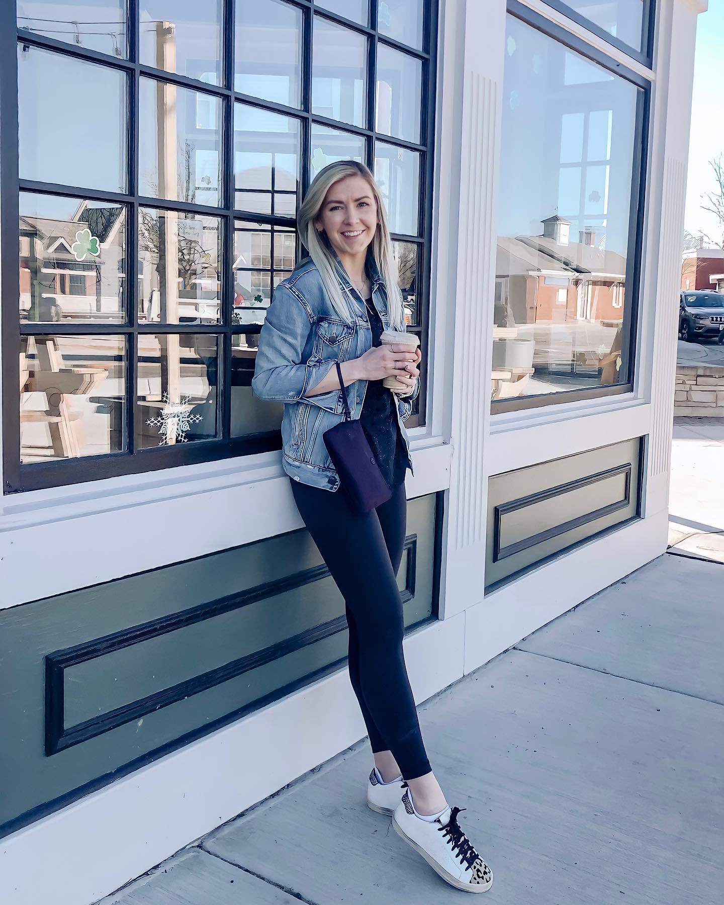 27 Jean Jacket Outfits You Need for 2026 12 Denim Jacket With Black Leggings And Cheetah Sneakers
