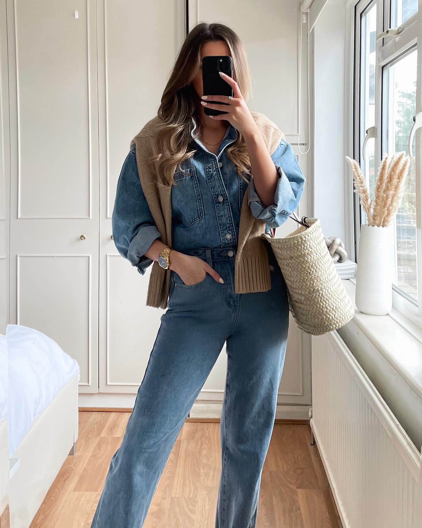25 Fall Going Out Outfits You Need for 2026 17 Denim Jumpsuit With Layered Knit And Straw Tote