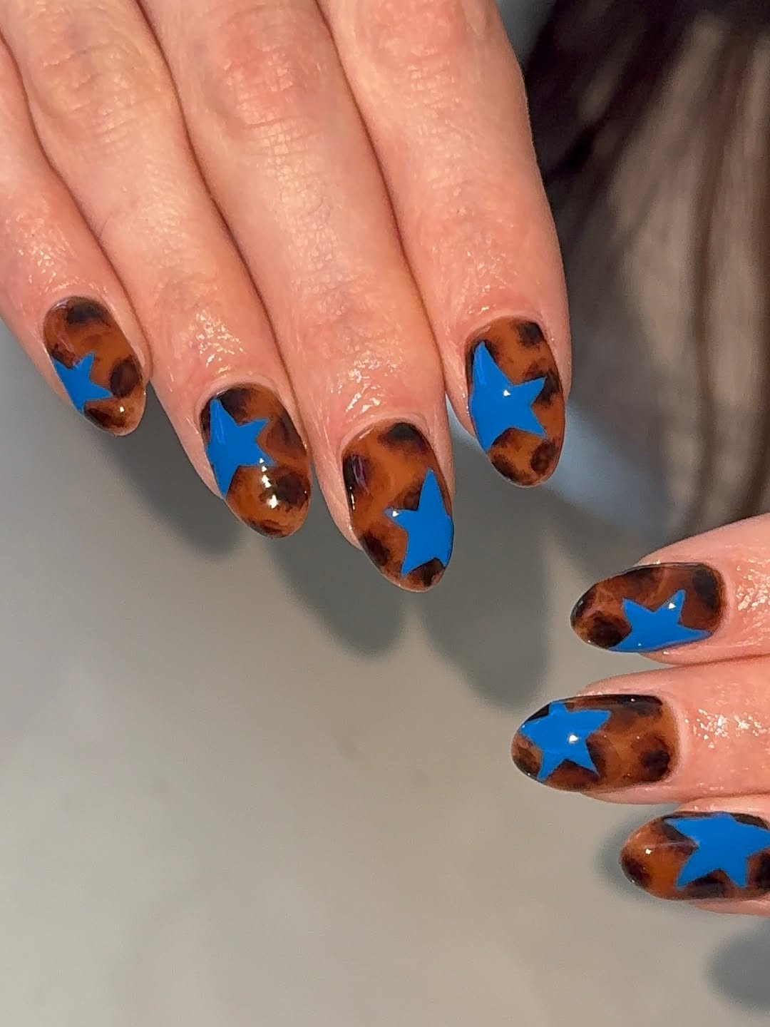 27 Tortoise Nail Trends You Need for 2026 16 Glossy Tortoiseshell Blue Star Oval Nails