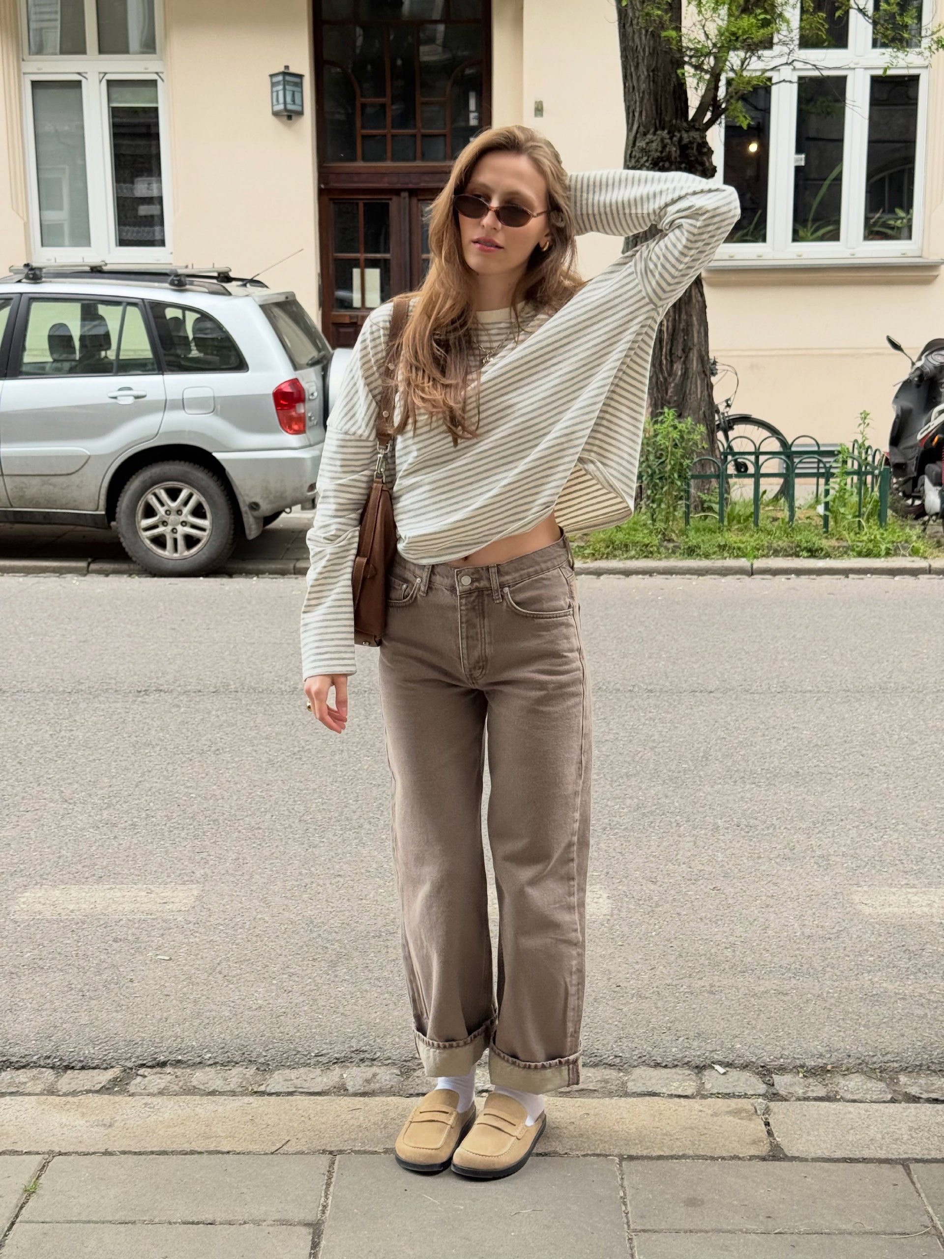 25 Fall Going Out Outfits You Need for 2026 10 Neutral Stripe Top With Brown Wide Leg Jeans