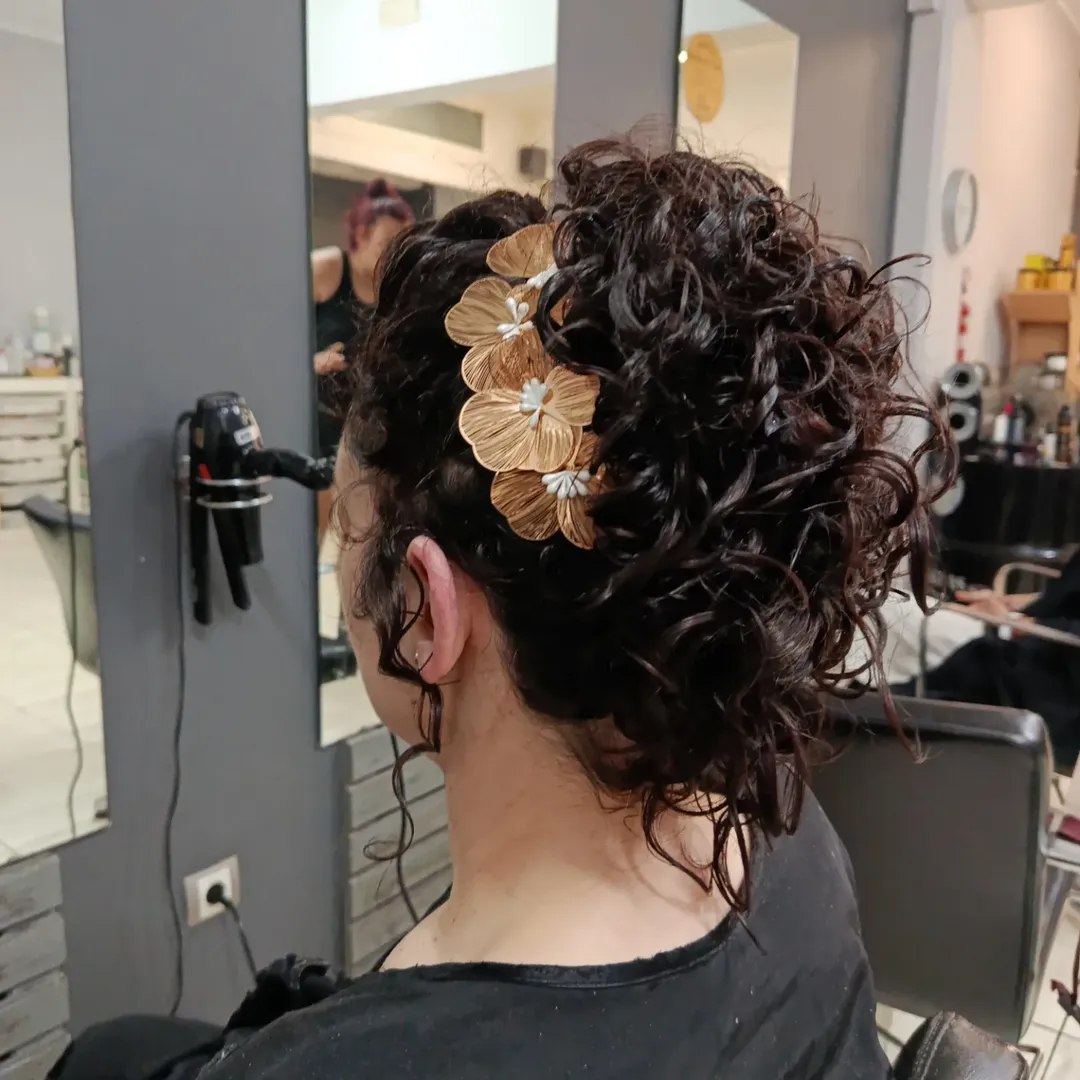 Updo With Loose Curls And Floral Hair Accessory