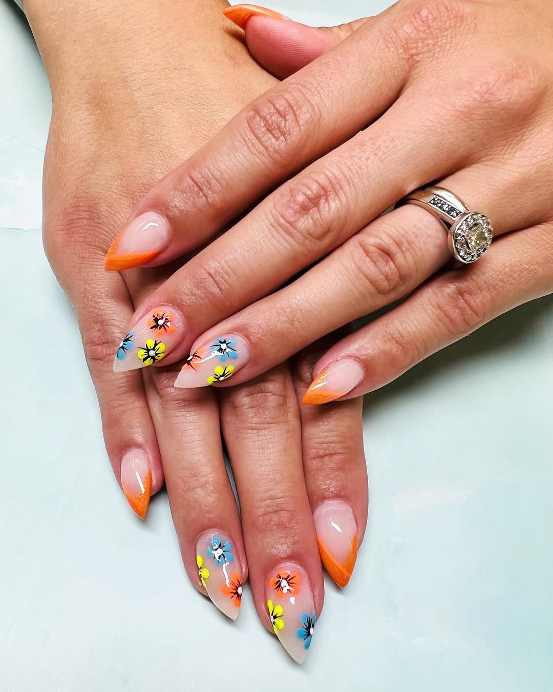 Vibrant Orange Tips with Playful Floral Nail Art