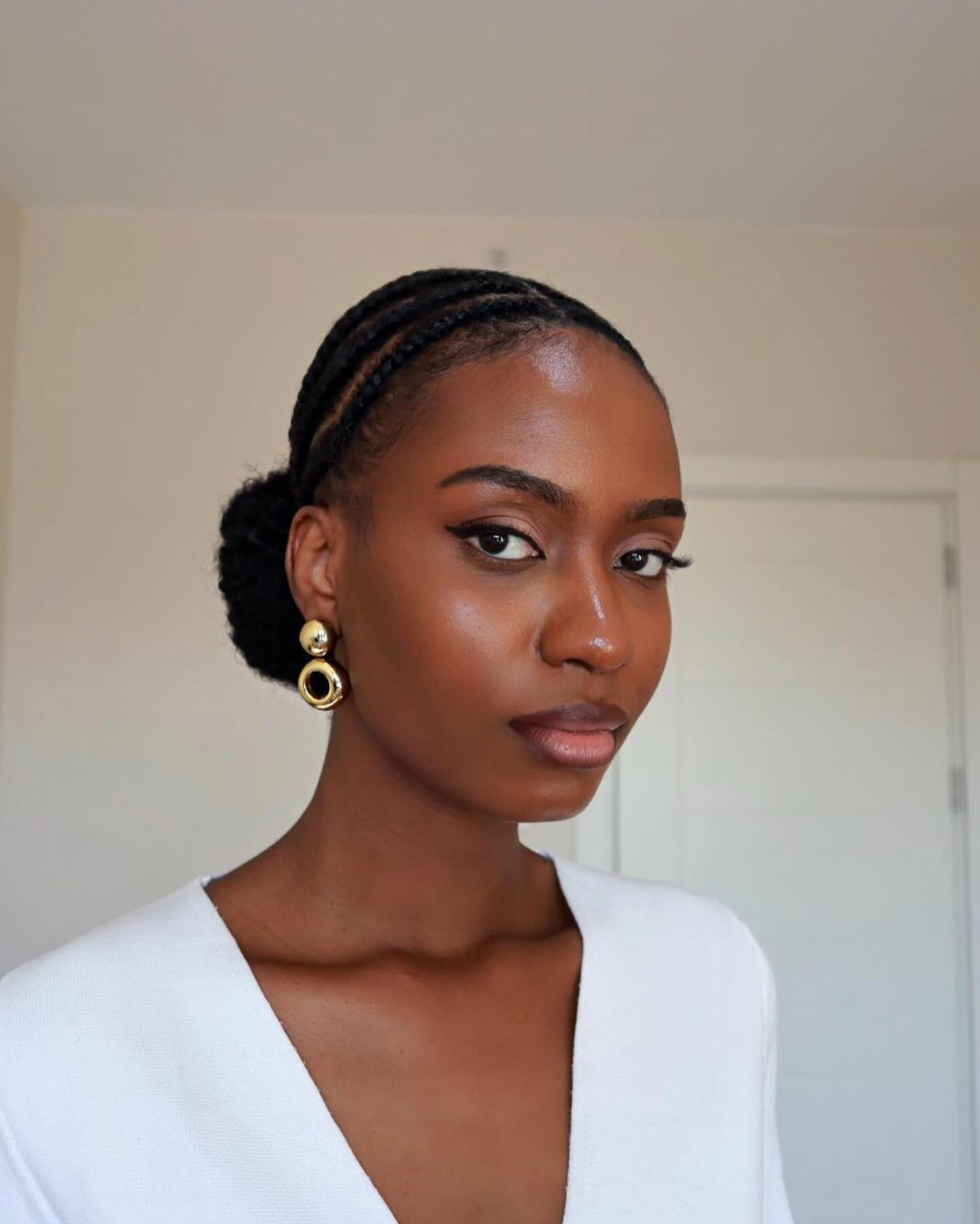 Sleek Cornrows With Low Bun And Defined Edges