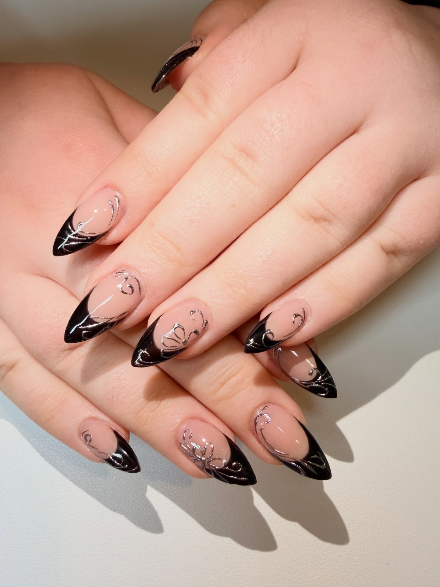 Glossy Black French Tip Stiletto Nails with Silver Swirls