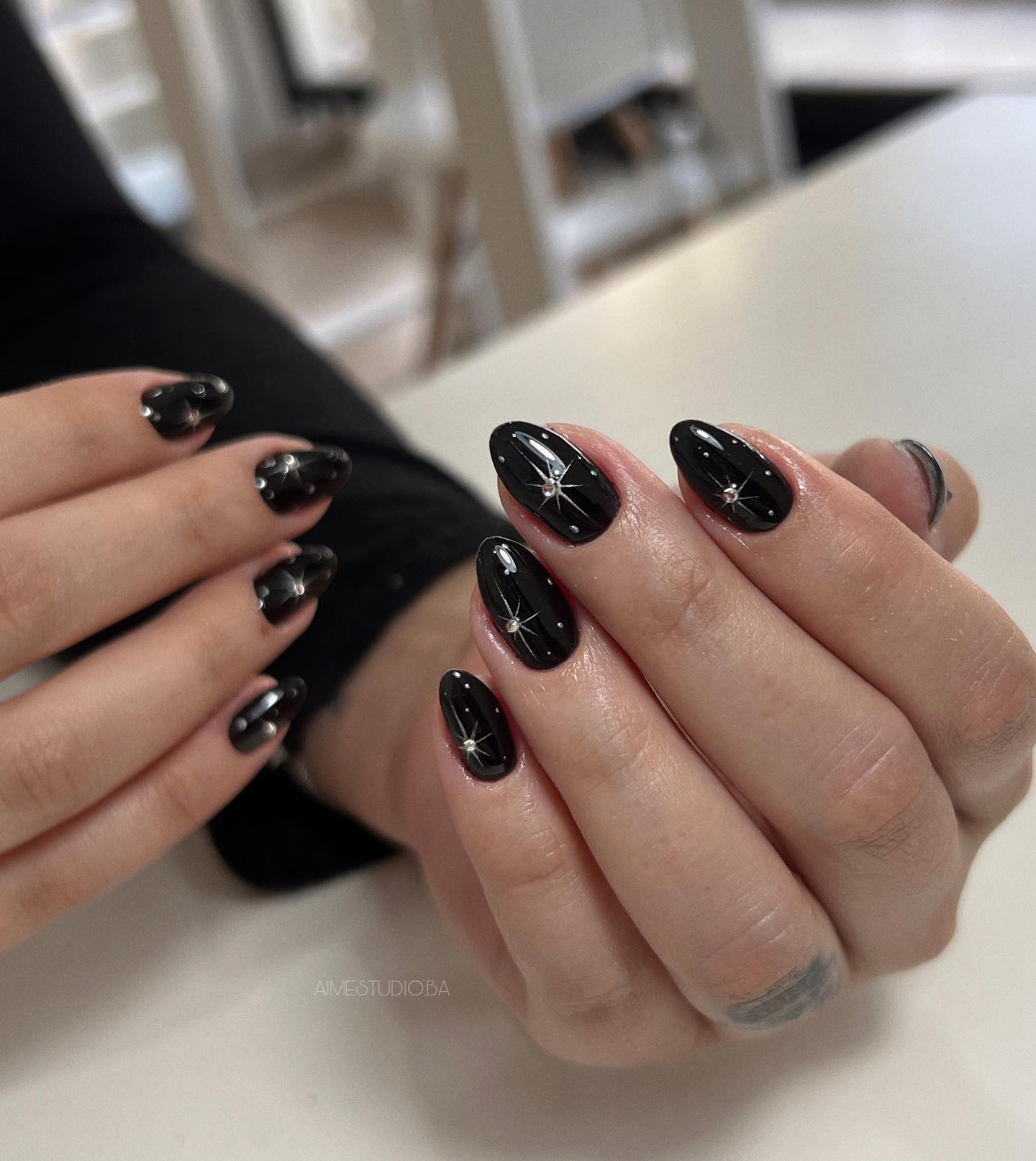 Glossy Black Starburst Almond Nails