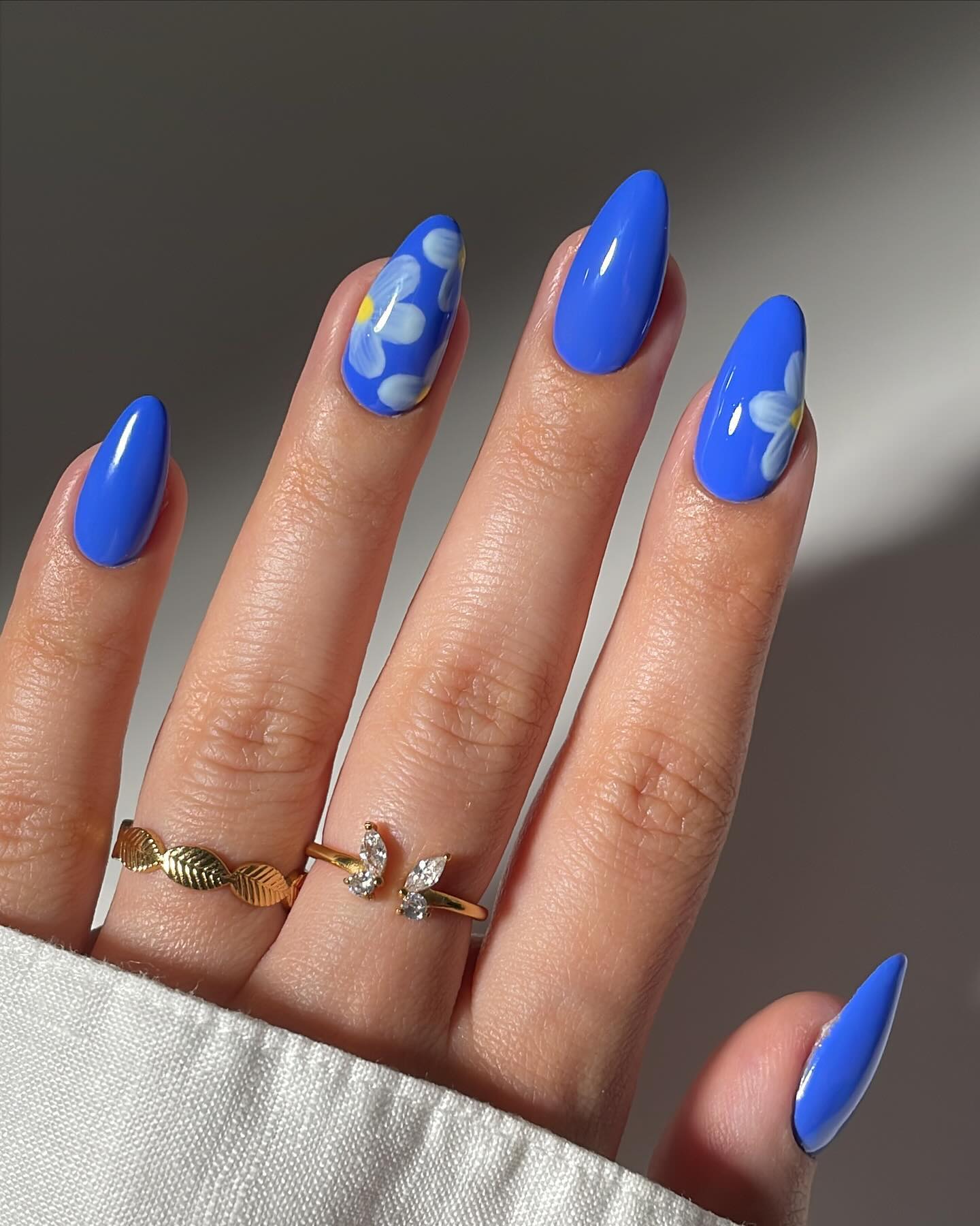 Glossy Royal Blue Almond Nails With Hand Painted Florals
