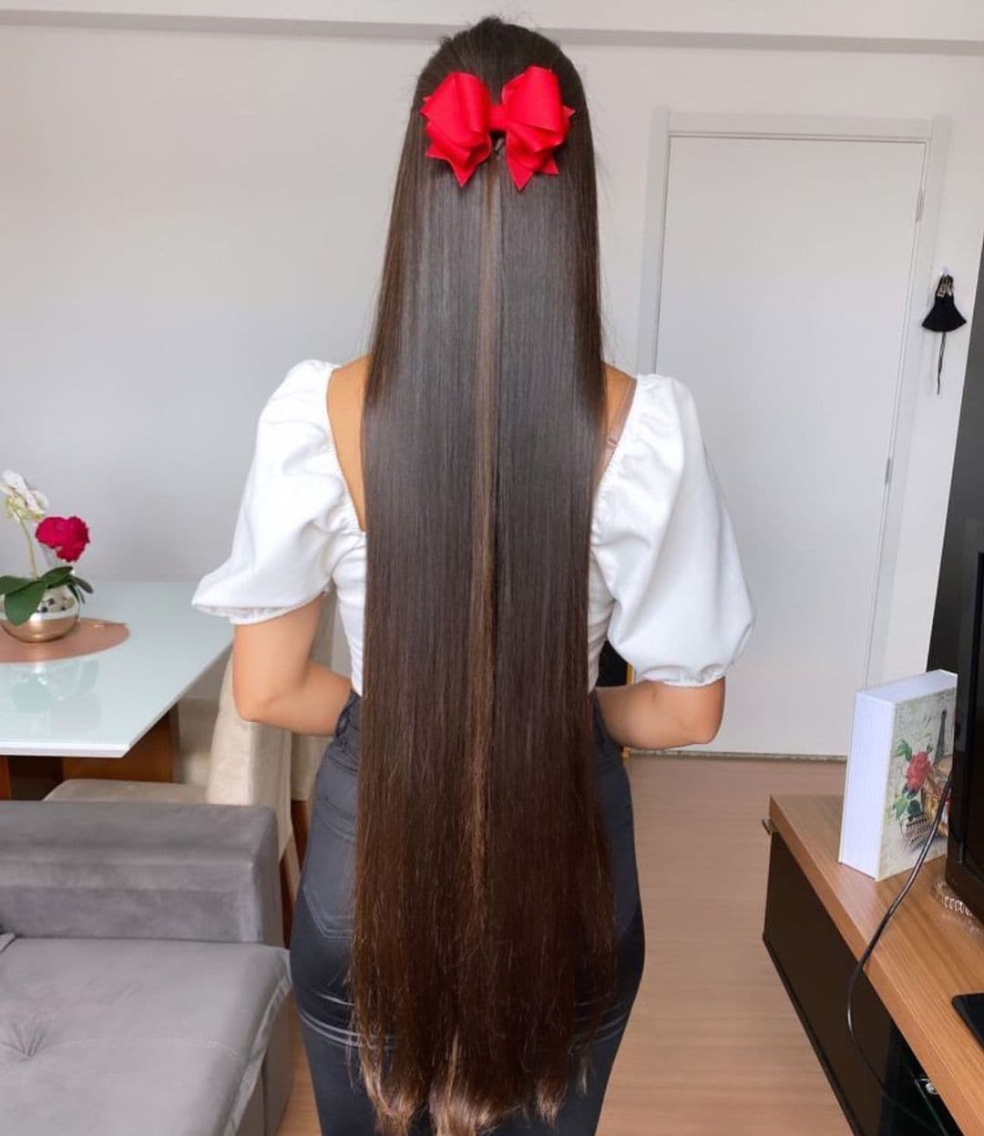 Sleek Waist Length Hair With Red Bow Accent