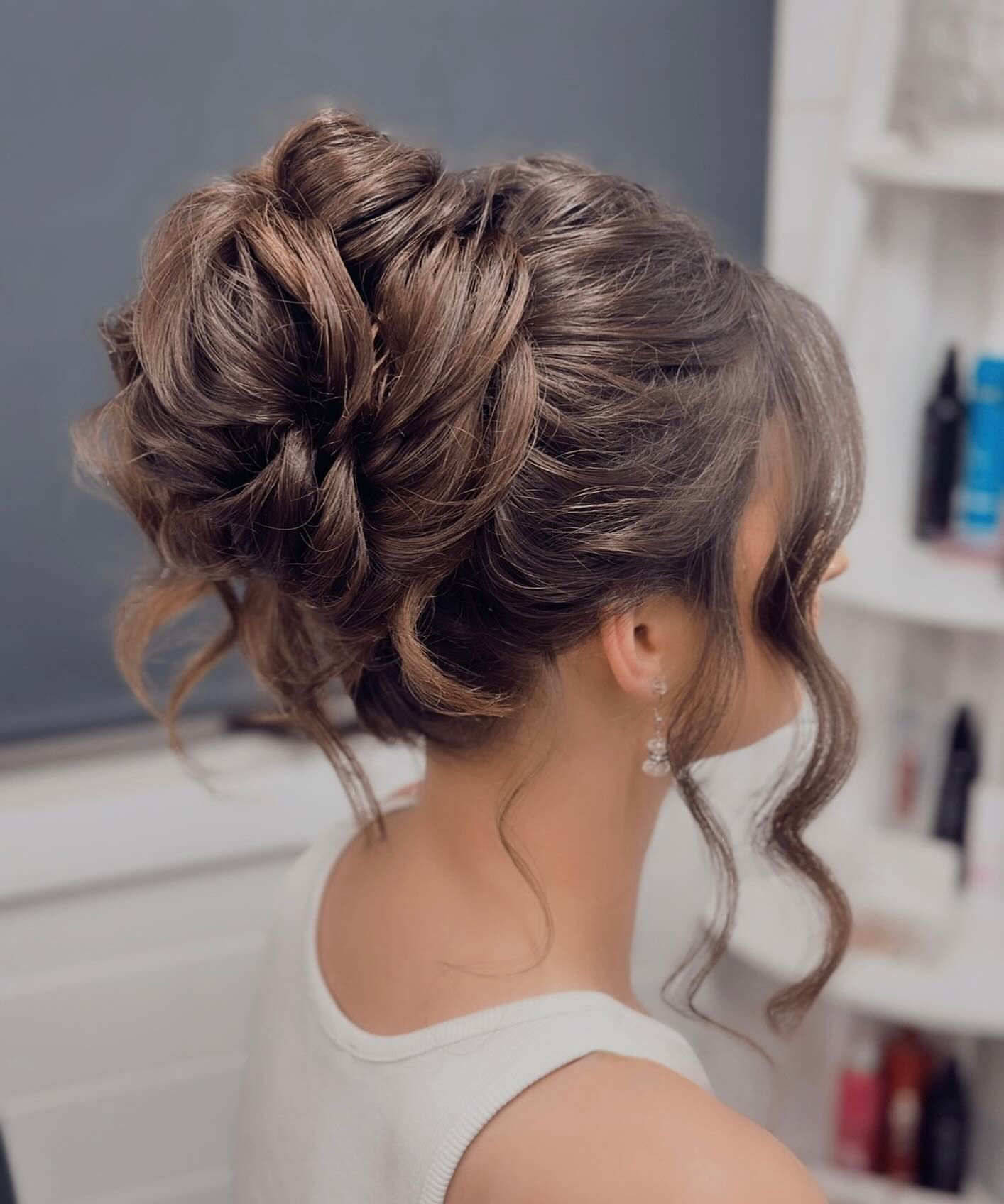 Textured Messy High Bun With Face Framing Tendrils