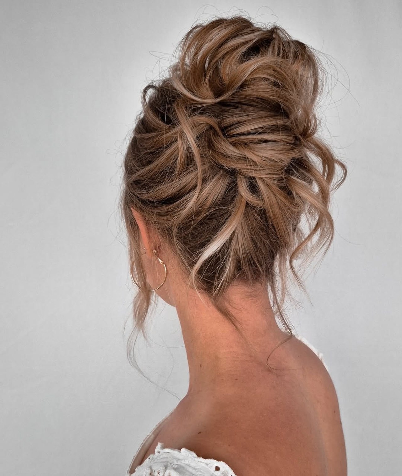 Textured Messy Updo With Soft Face Framing Highlights