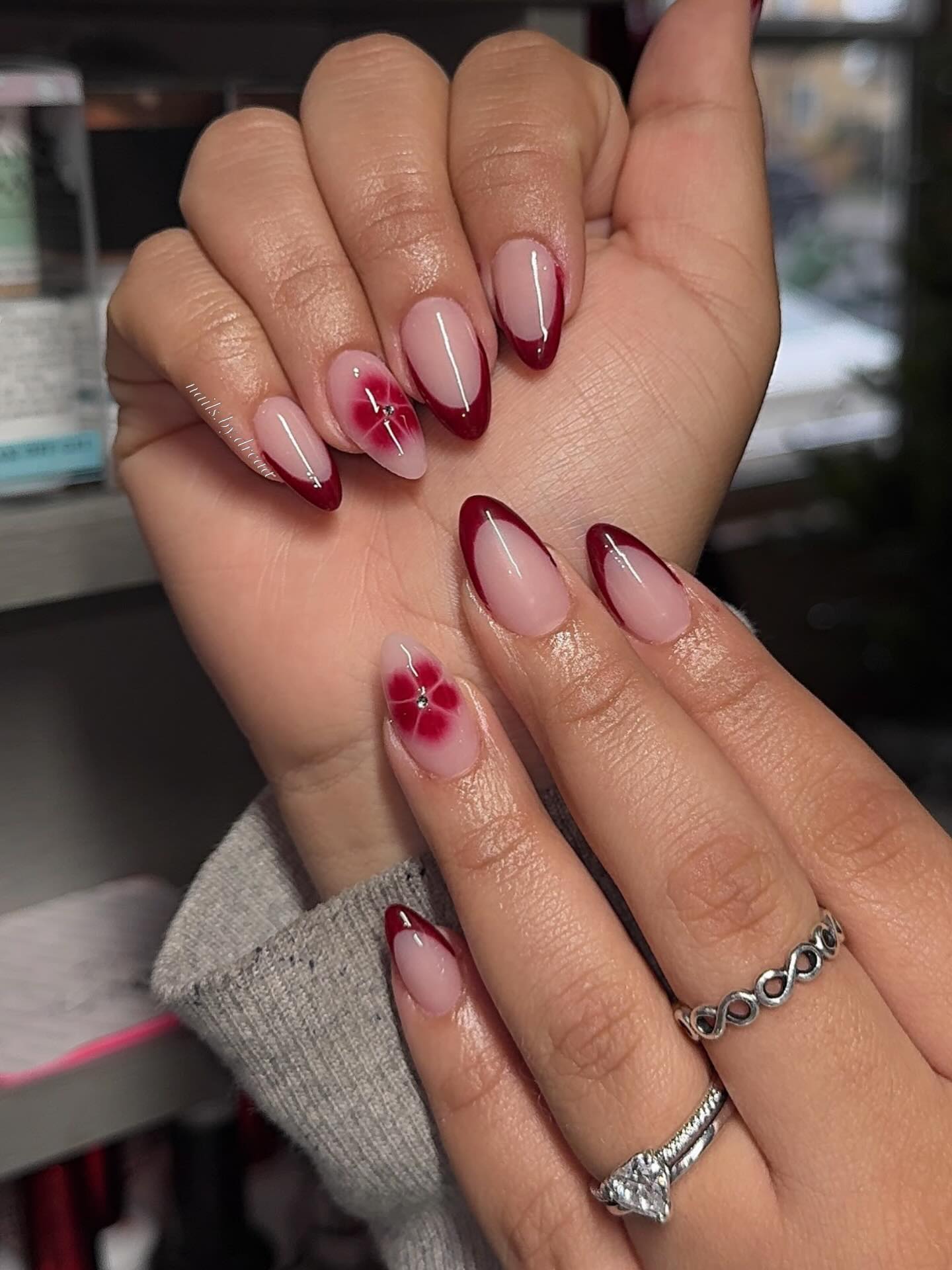 Deep Red French Almond Nails with Floral Accent