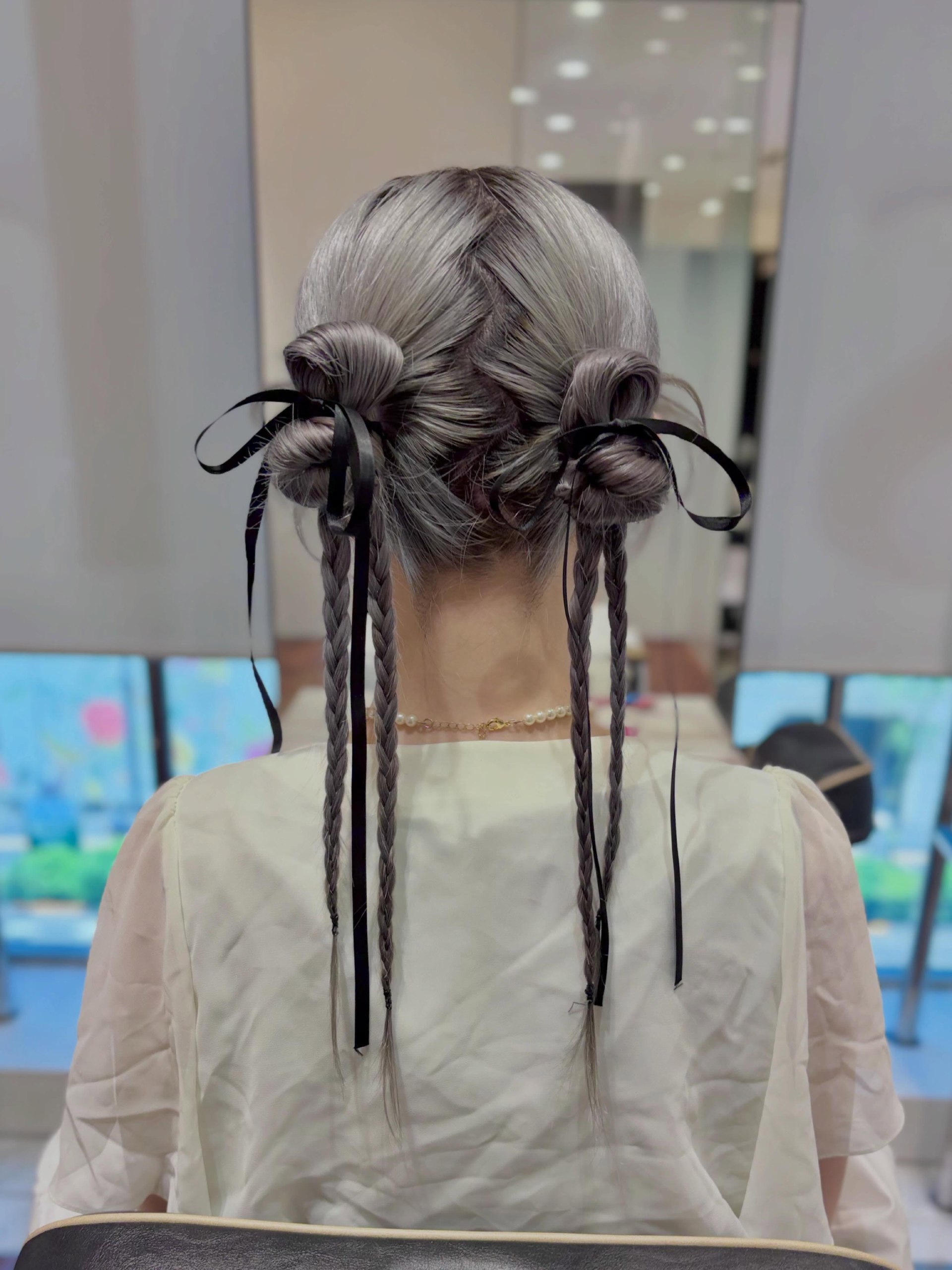 Double Space Buns With Braids And Ribbon Accents