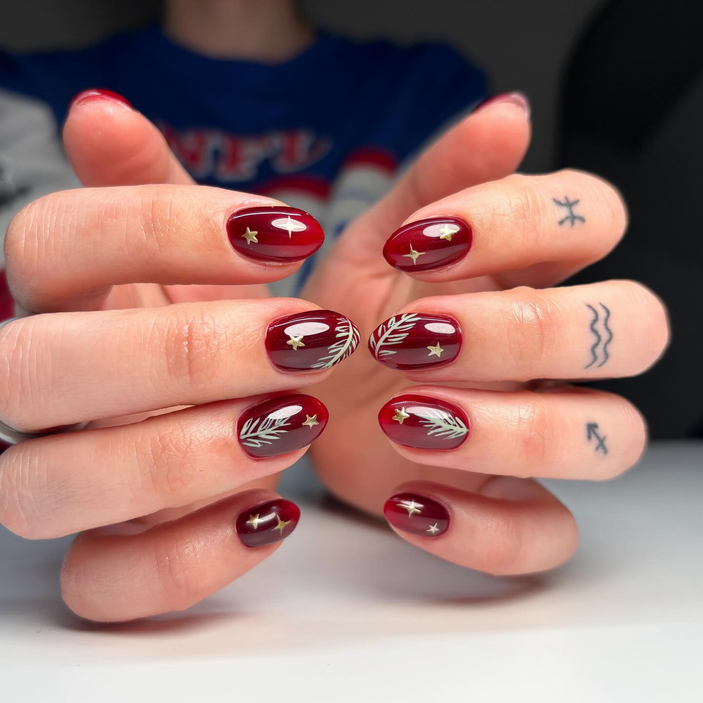 Deep Red Oval Nails with Gold Stars & Foliage