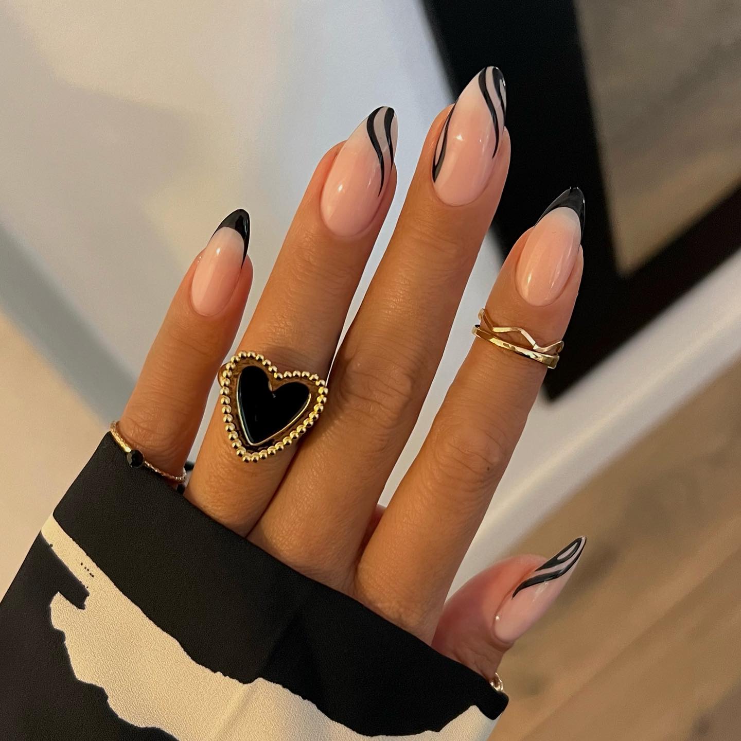 Glossy Nude Almond Nails With Black French And Swirls