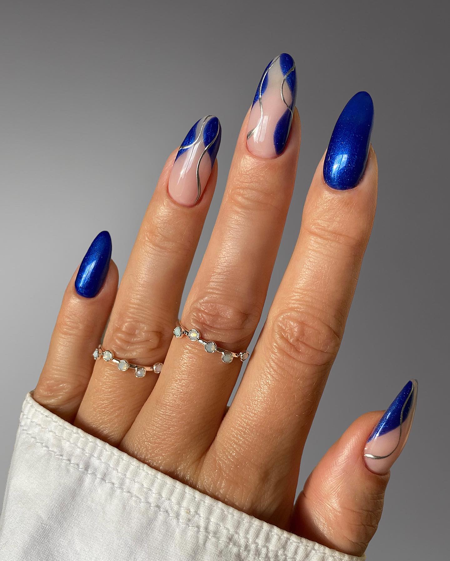 Glossy Royal Blue Almond Nails With Silver Swirls