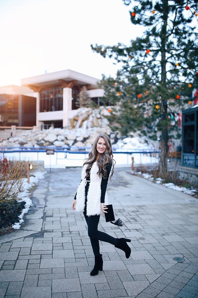 White faux fur vest over black basics — New Years Eve Outfits Casual
