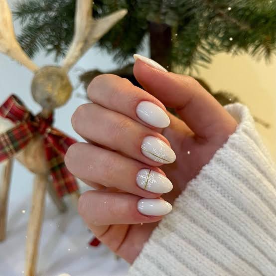Glossy White Oval Nails With Gold Snowflake Art — Winter White Nails